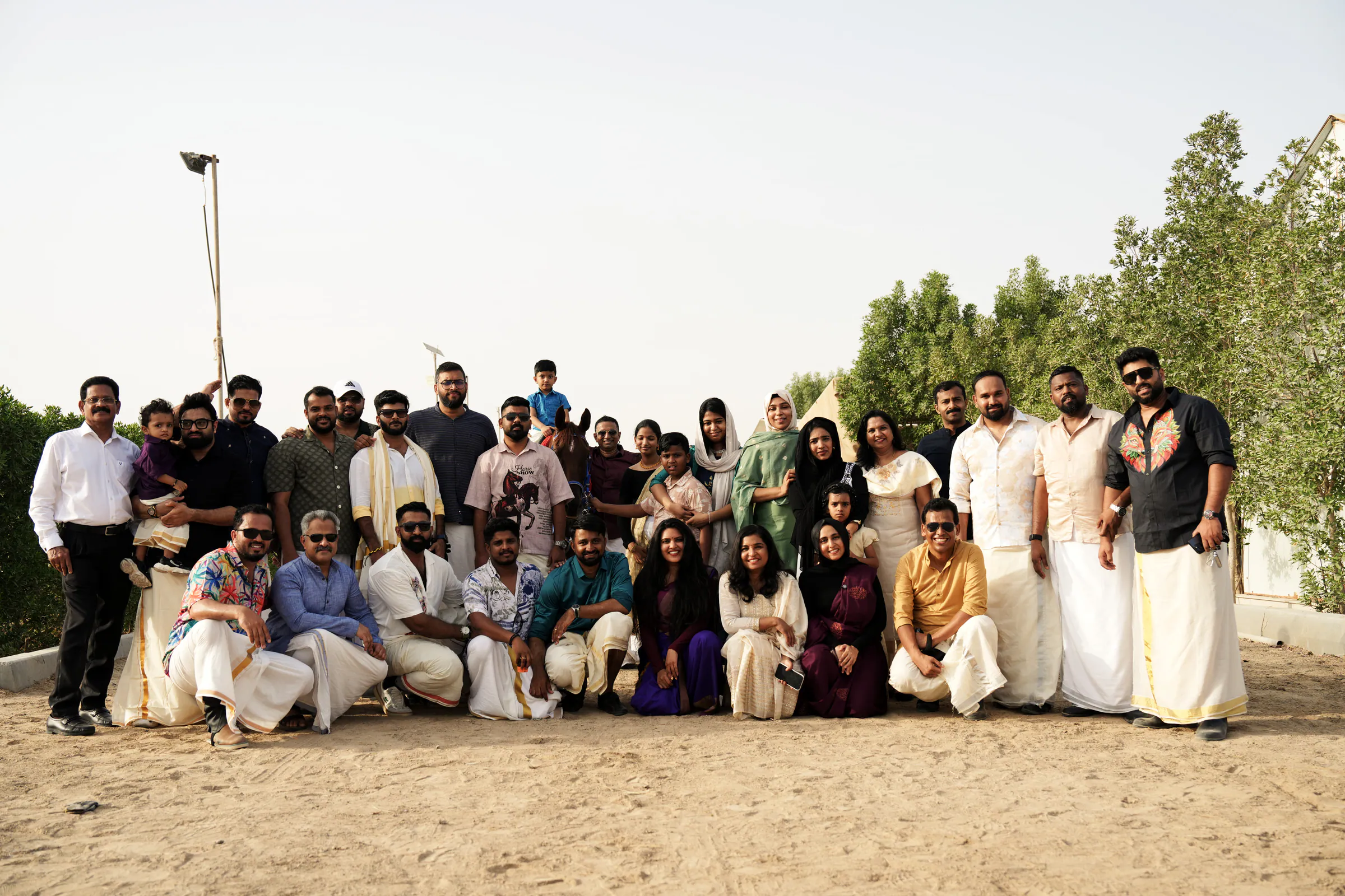 Club members and families in traditional Onam dress gathered for a group photo
